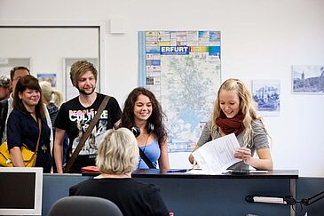 Studierender lässt sich an Theke beraten