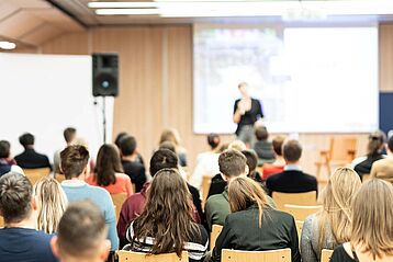 Female speaker giving presentation on business conference.