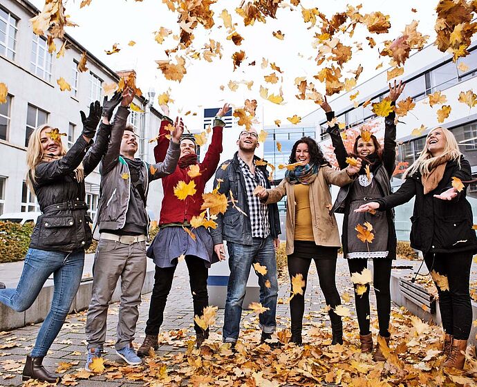 Gruppe Studierende stehen vor der FH im Herbst