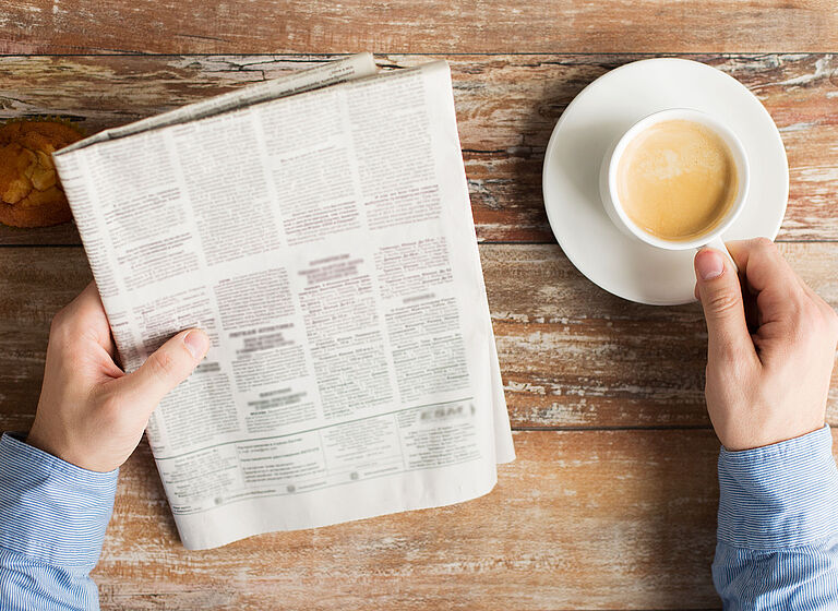 close up of male hands with newspaper